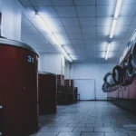 Interior view of a contemporary laundromat featuring red washing machines under fluorescent lights.