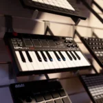 Close-up of an Akai MPK mini play MIDI controller keyboard displayed on a store wall.