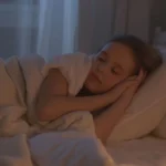 A serene child sleeping in a warmly lit cozy bedroom, embodying peace and comfort.